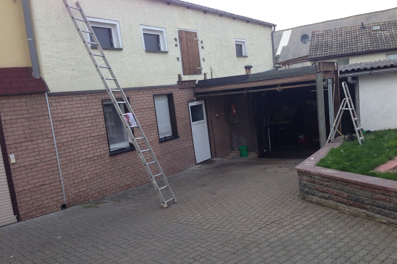 Scène avec une maison, un garage et deux échelles.