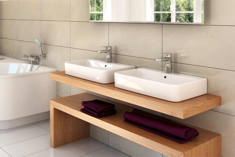 Helles Badezimmer mit zwei Waschbecken, Holzunterschrank und Badewanne