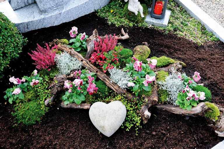 Aménagement de tombe avec plantes, bois et un cœur en pierre