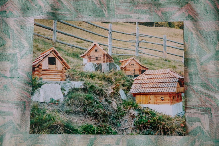 Photo de quatre petites maisons en bois dans un environnement rural