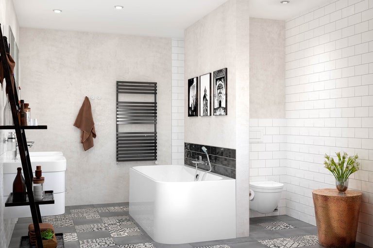 Salle de bains moderne avec baignoire, sèche-serviettes, lavabo, toilettes et éléments décoratifs.