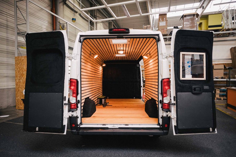 Vue intérieure d'une camionnette avec garniture en bois et portes arrière ouvertes