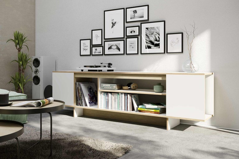 Salon avec meuble bas blanc, platine vinyle et photos décoratives au mur
