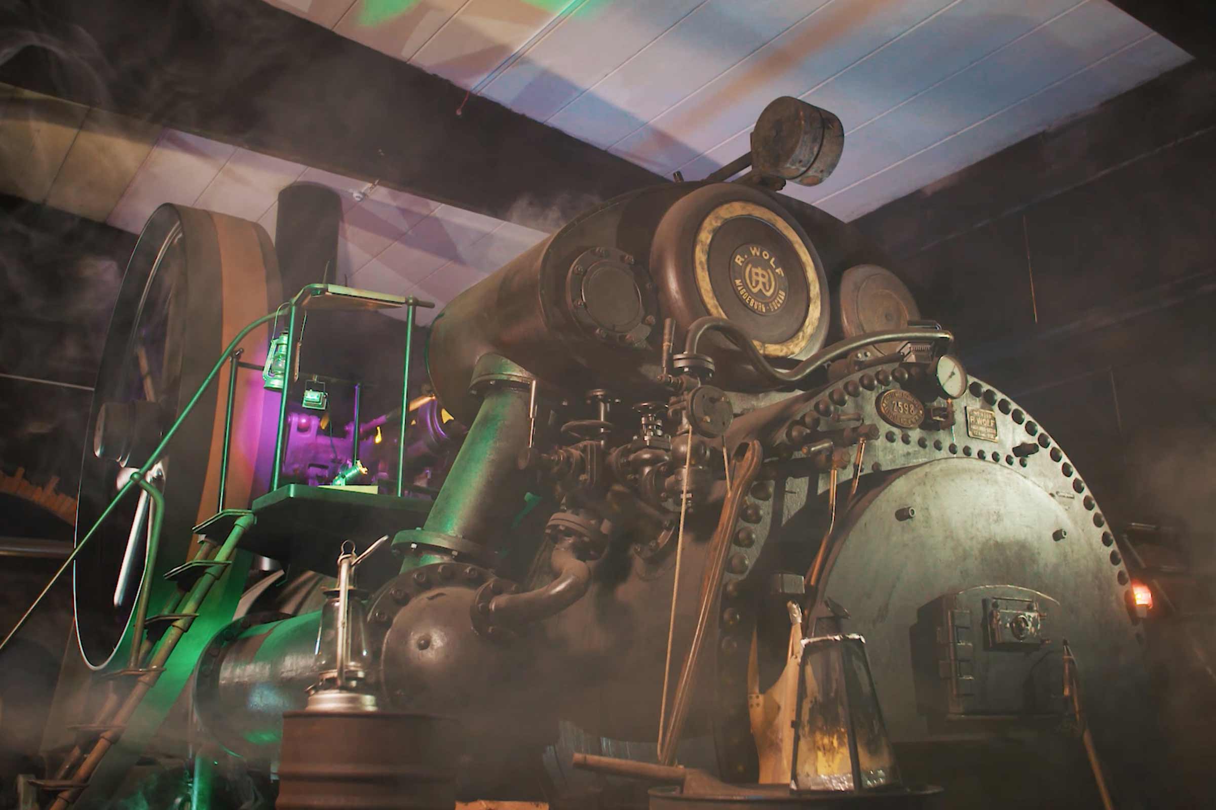 Gros plan d'une machine à vapeur fixe historique, mettant en valeur la précision mécanique et le passé industriel.