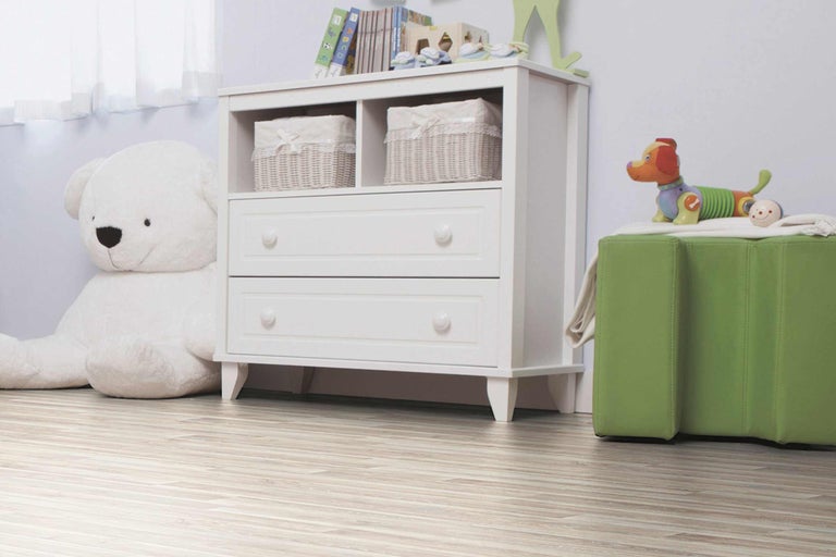 Kinderzimmer mit weisser Kommode, Spielzeug und Holzboden