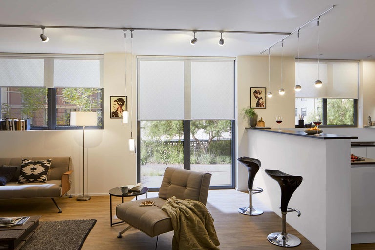 Wohnzimmer mit Sofa, Sessel, Bar, Deckenleuchte und Rollos