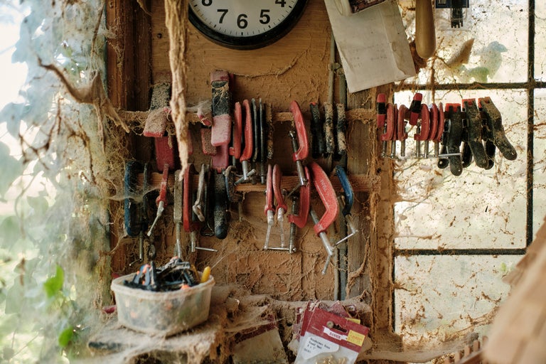 Mur d'atelier avec serre-joints, horloge, outils et vis