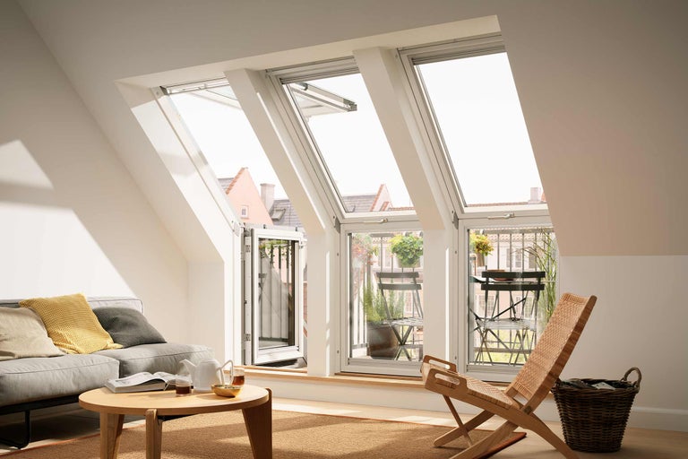 Heller Dachbodenraum mit Dachfenstern, Sofa, Tisch und Stuhl