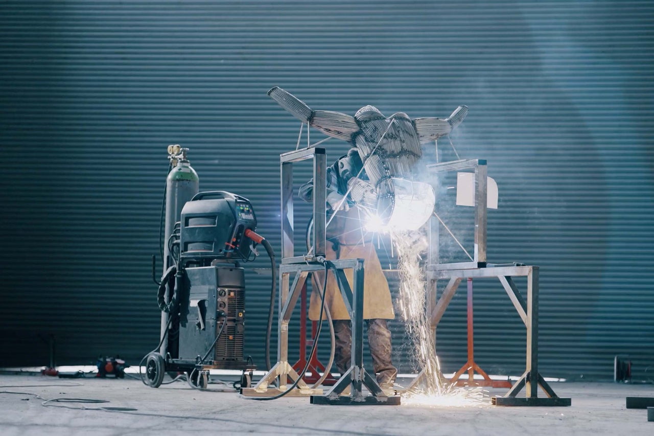 Schweisser bei der Arbeit an einer Metallskulptur mit Schweissgerät