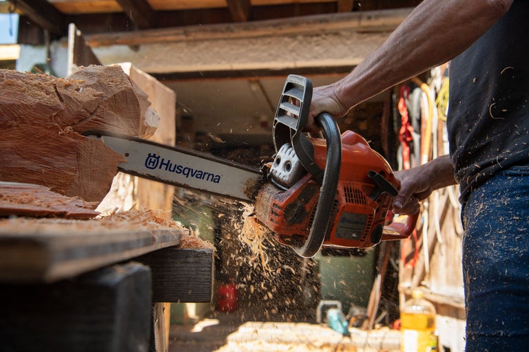 Une tronçonneuse Husqvarna coupe du bois.