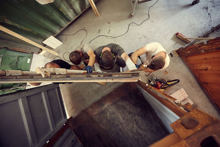 Vue de dessus de trois artisans travaillant sur un projet de construction