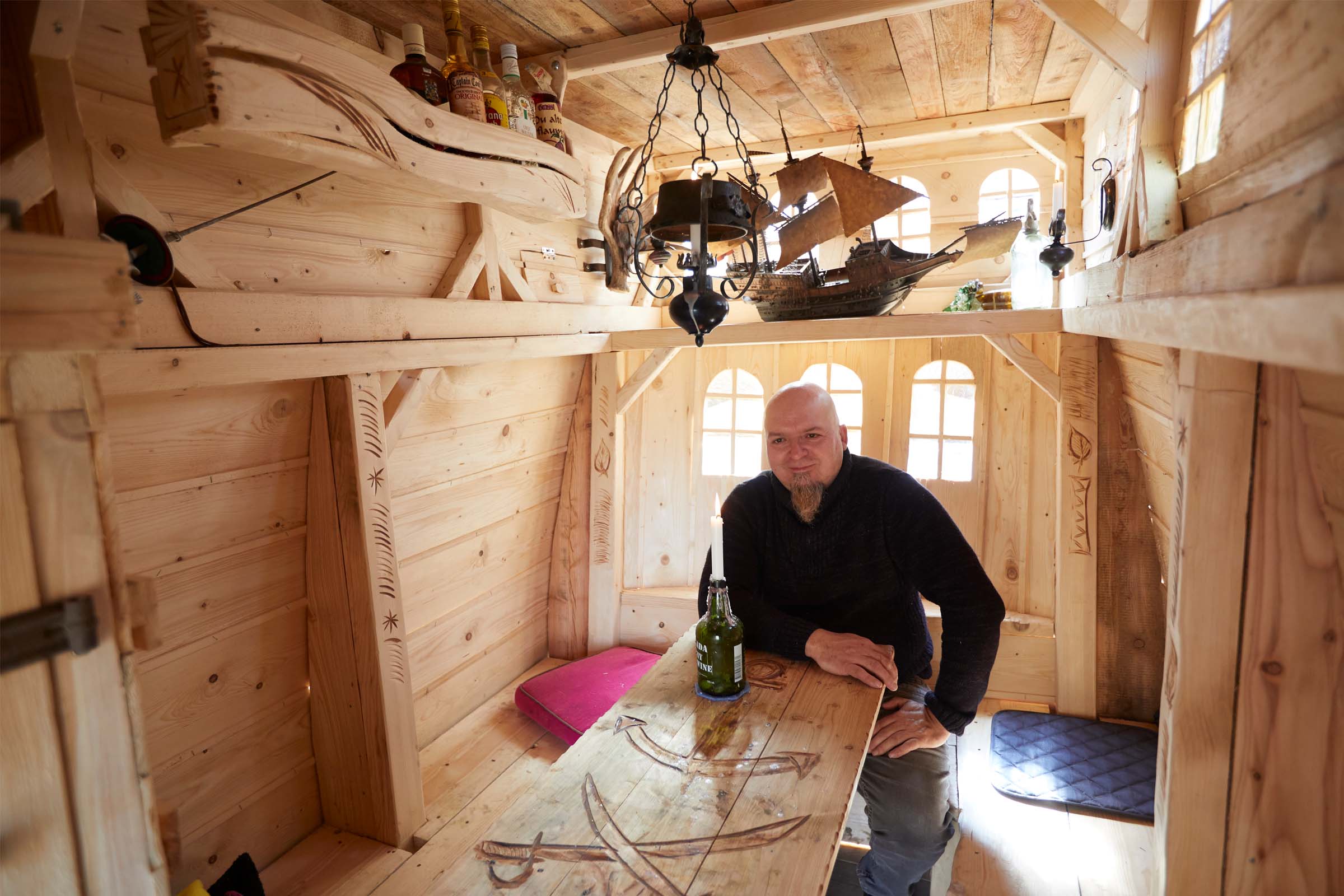 Maison de jeux en bois de style marin avec un homme à table