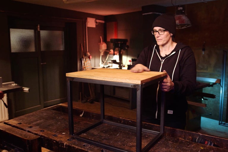 Table d'appoint carrée avec plateau en bois et cadre en métal dans un atelier