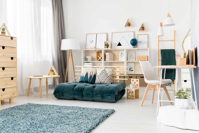 Espace de vie lumineux avec matelas bleu-vert, étagères et éléments en bois