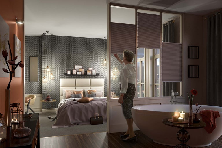 Chambre et salle de bains avec stores plissés en guise de séparation de pièce.