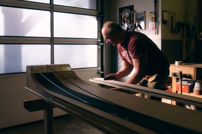 Artisan travaillant sur une construction en bois dans un atelier.