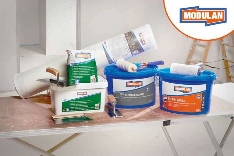 Présentation de produits avec enduit de réparation Modulan, primaire d'accrochage, peinture Expertweiss, voile de peintre et outils