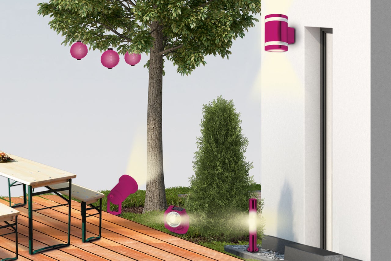 Espace extérieur avec arbre, table de bistrot et plusieurs luminaires de jardin