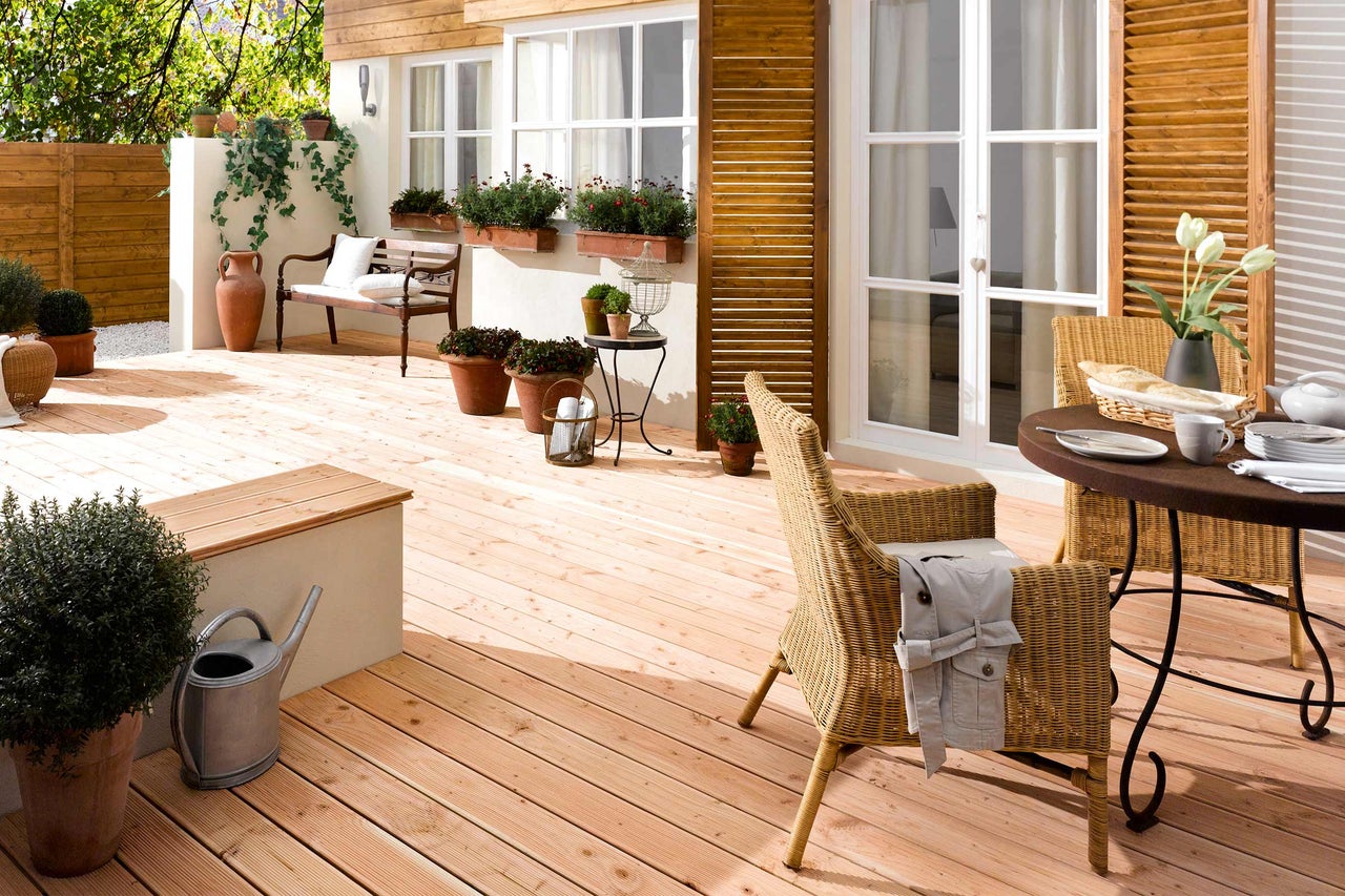 Terrasse mit Holzboden, Gartenmöbeln und Pflanzen