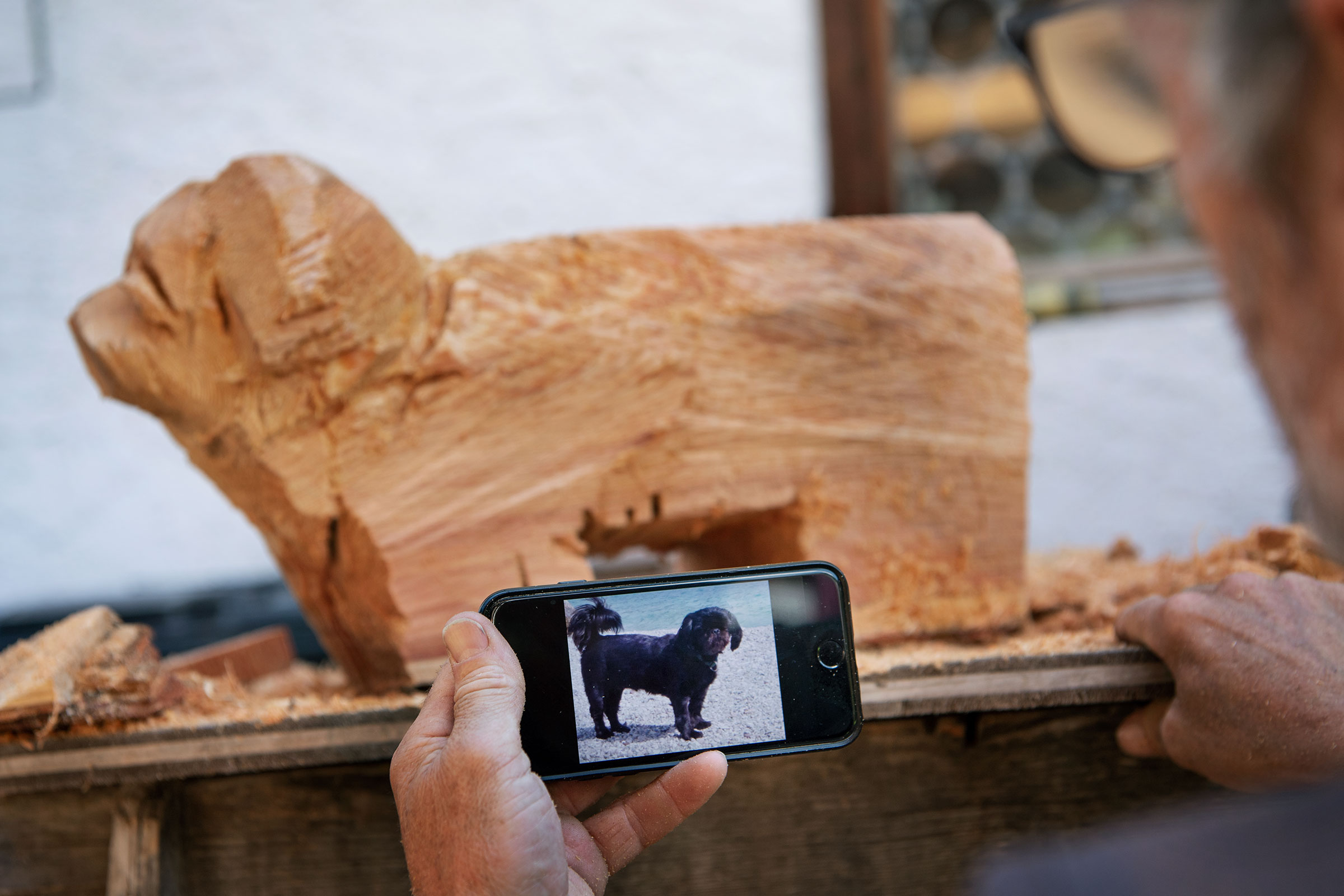 Ébauche en bois d'un chien et un téléphone portable avec une photo d'un chien