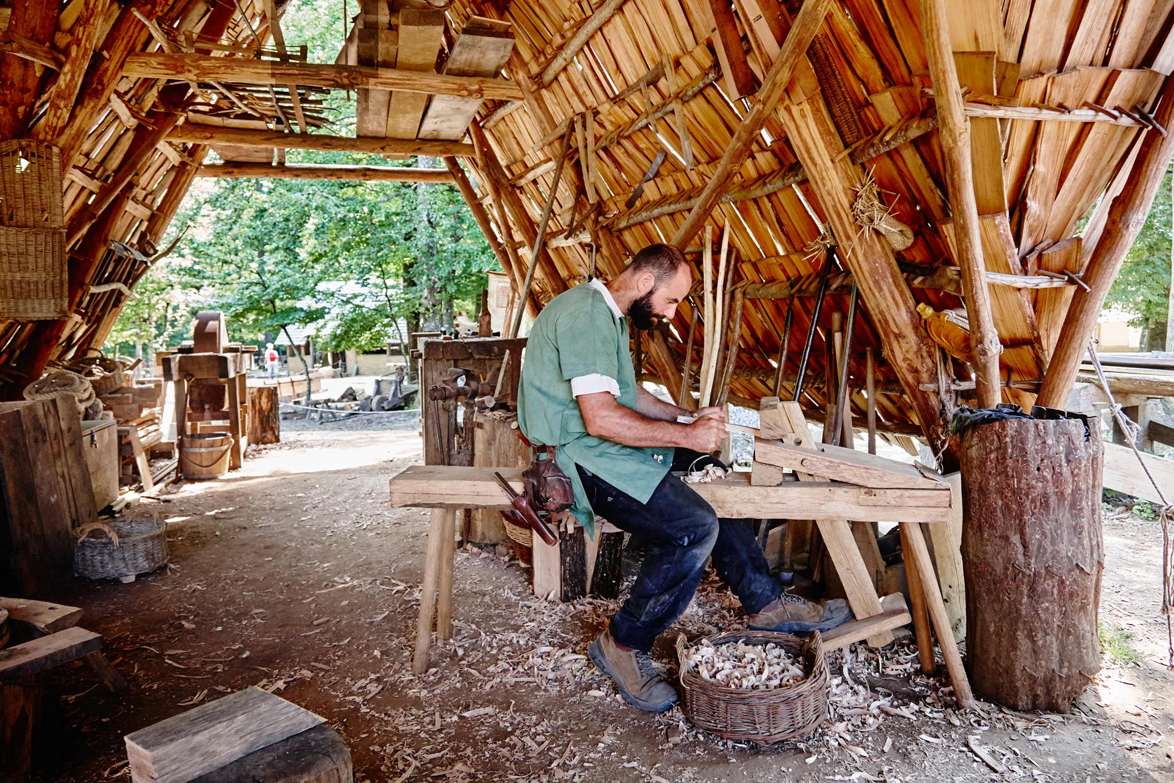Un artisan travaille dans un atelier de bois avec un toit en bois.