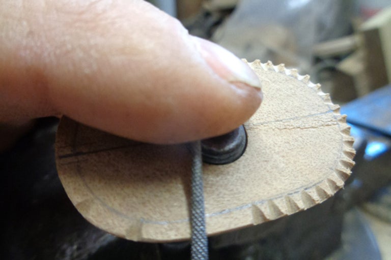 Gros plan d'une pièce de bois travaillée avec une lime, vue rapprochée du travail du bois