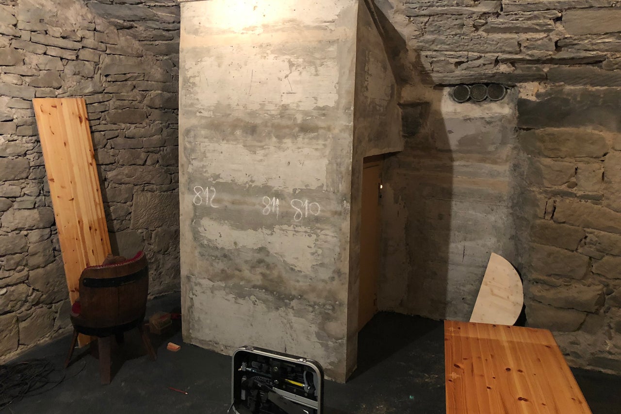 Kellerraum mit Steinwänden, Putzwand und Holzgegenständen