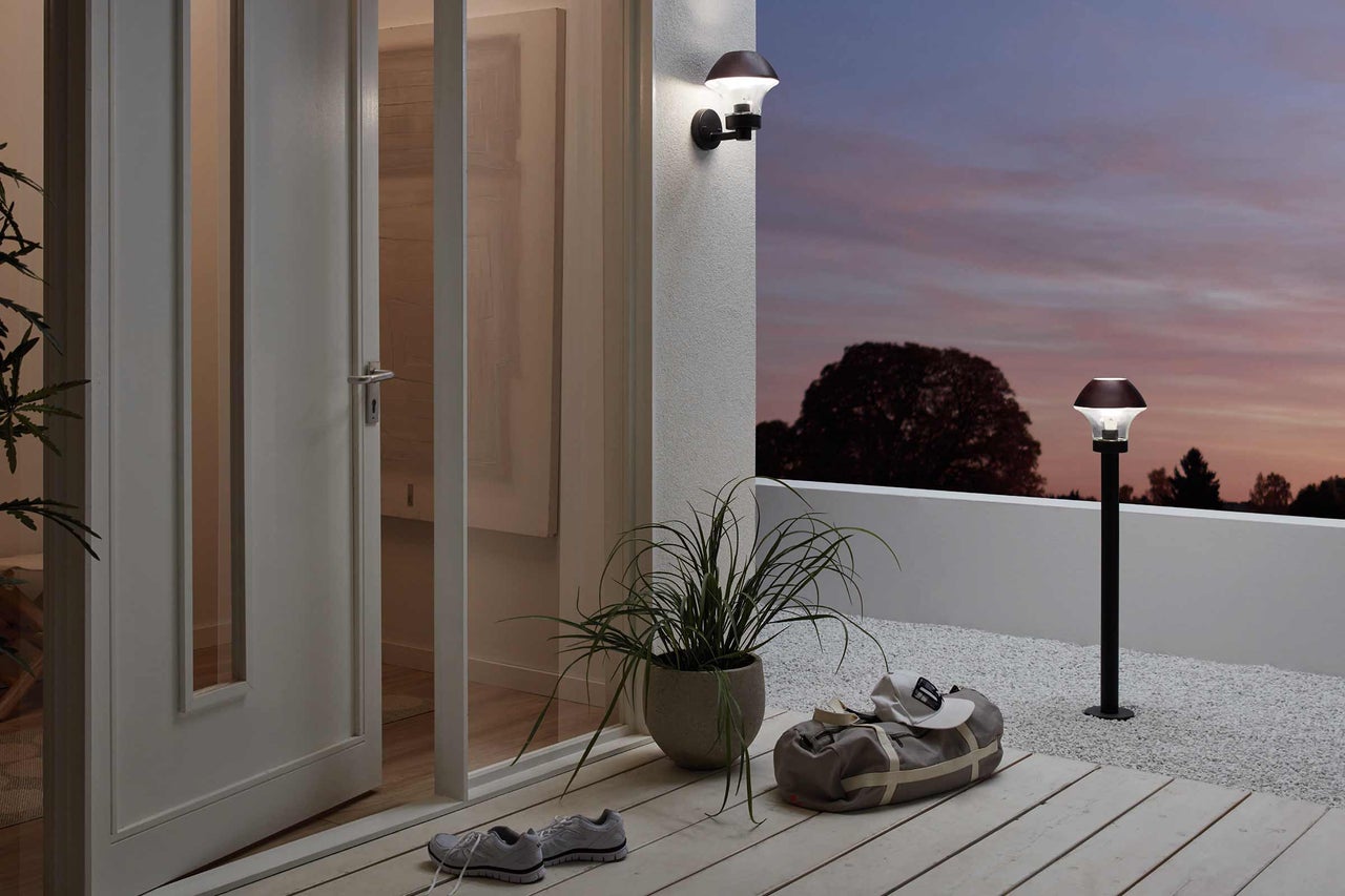 Terrasse mit Wand- und Sockelleuchte, Pflanze im Topf und Sporttasche