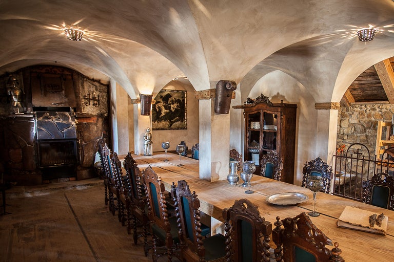 Longue table en bois avec des chaises dans une pièce avec un plafond voûté