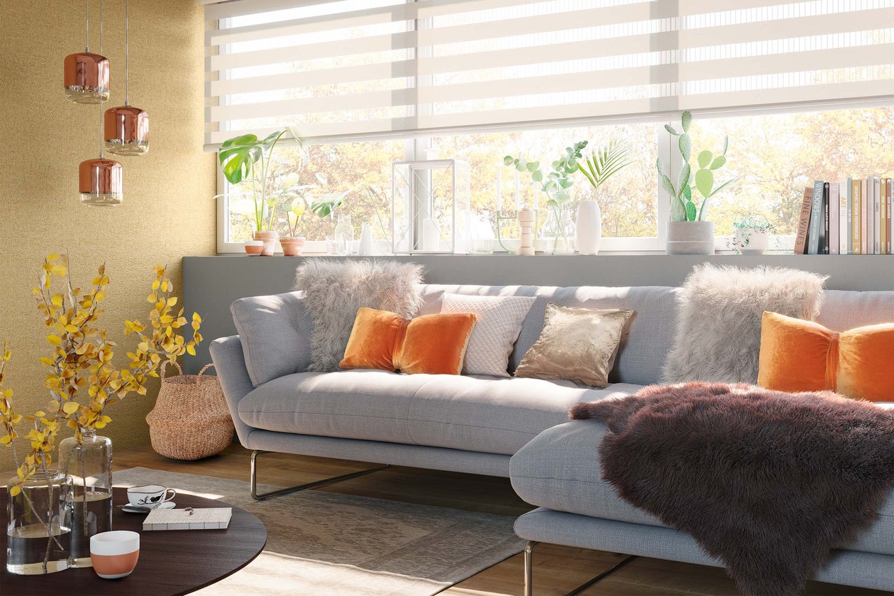 Wohnzimmer mit Sofa, Kissen, Decken, Tisch und Dekorationen für Wohnraumgestaltung