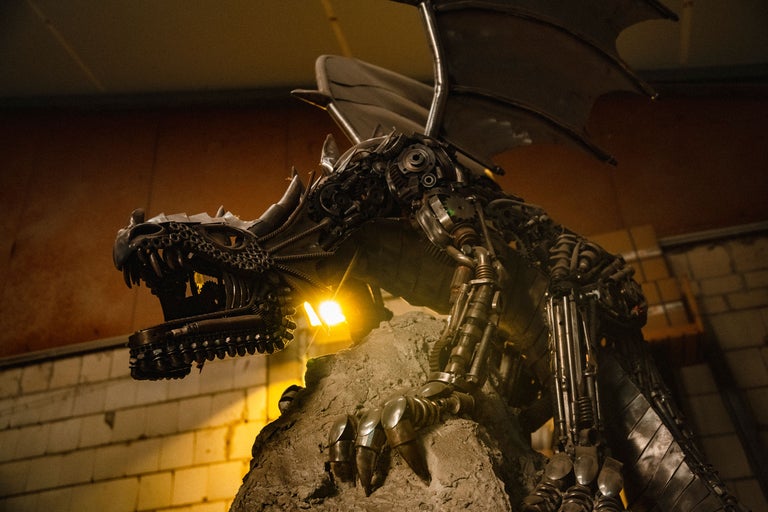 Sculpture de dragon en métal sur un socle en pierre