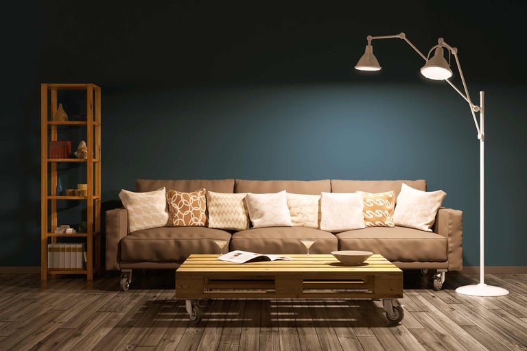 Wohnzimmer mit Sofa, Stehlampe und Regal