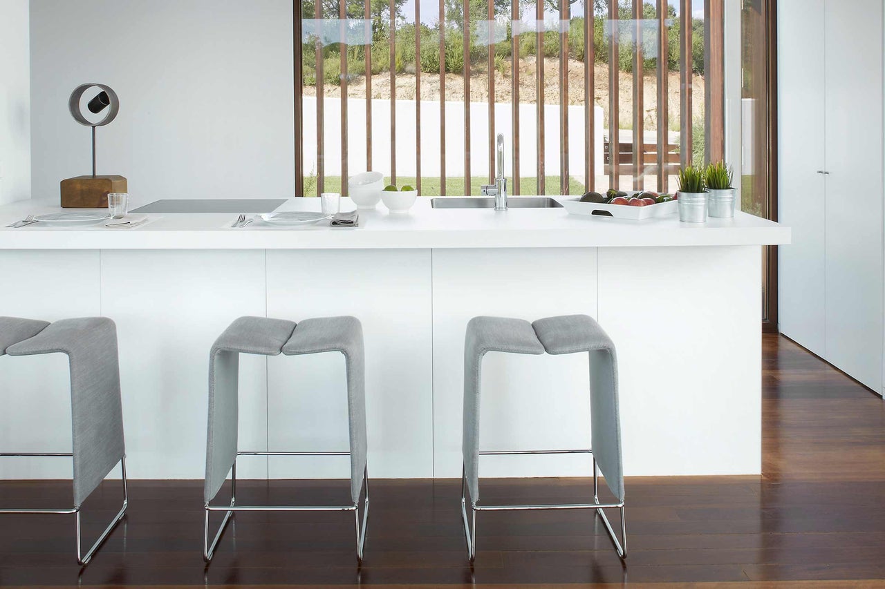 Cuisine moderne avec tabourets de bar, évier et décoration sur le plan de travail