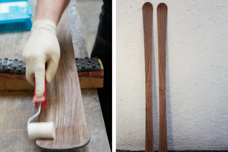 Deux skis en bois et une personne appliquant un produit sur un ski.
