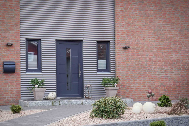 Façade d'une maison avec porte d'entrée, fenêtres, boîte aux lettres et éclairage extérieur