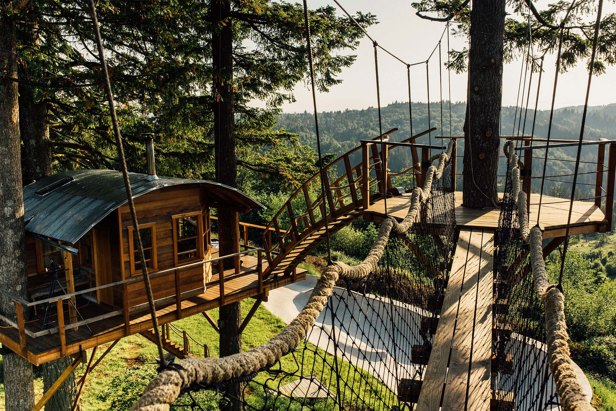 Cabane dans les arbres avec maison en bois et pont suspendu dans la forêt