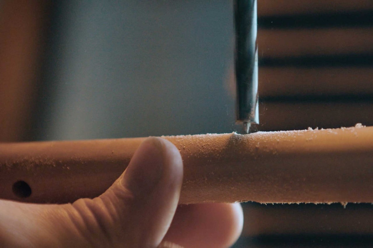 Une perceuse perce un trou dans une pièce de bois.