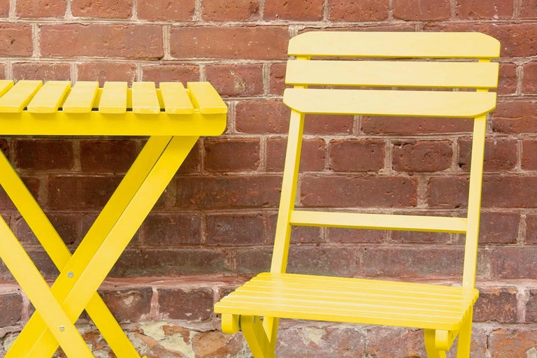 Gelber Klapptisch und Stuhl vor einer Ziegelwand