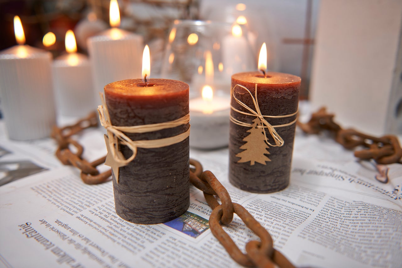 Bougies décoratives avec garniture et chaîne rustique sur un journal