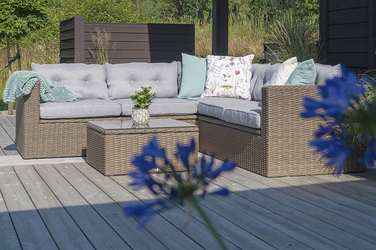 Rattan Lounge-Set mit Tisch und Polsterauflagen auf einer Terrasse