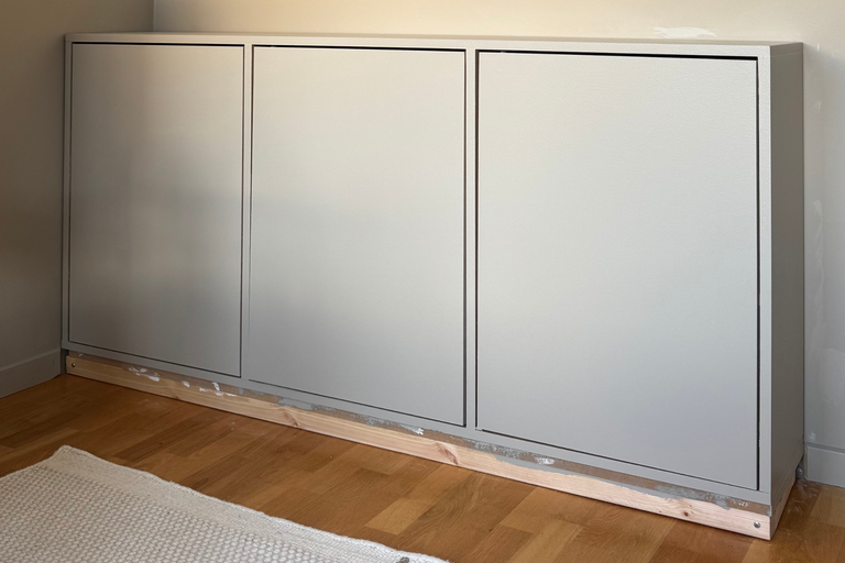 Wandschrank mit drei Türen auf Holzbalken