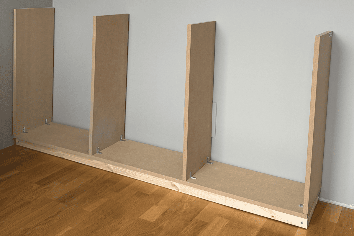 Rohbau eines Bücherregals aus Holz und MDF-Platten an einer Wand