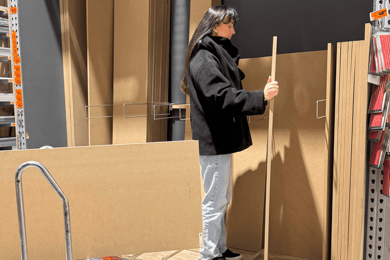 Kundin wählt eine Holzplatte im Hornbach Baumarkt aus