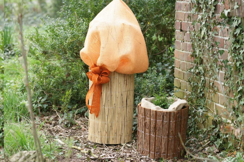 Scène de jardin avec des pots de fleurs en bambou et en bois pour protéger les plantes en hiver