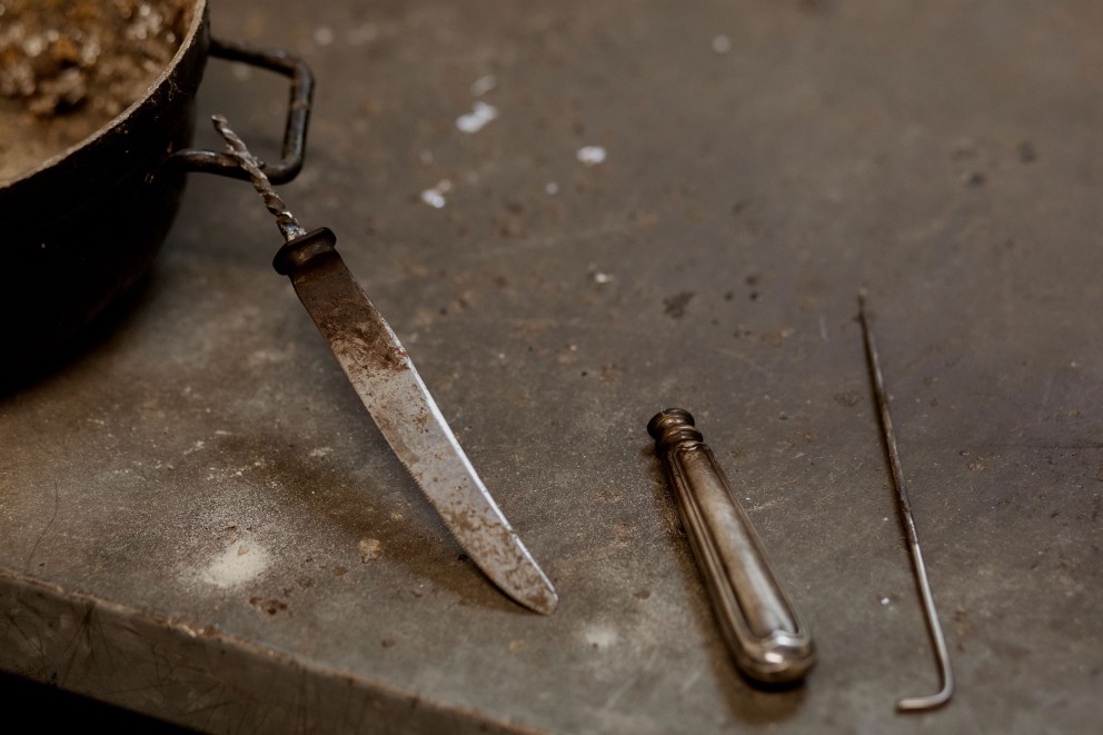 
				Le manche est séparé de la lame. C&lsquo;est l&lsquo;une des étapes de travail de la restauration d&lsquo;un couteau en argent à l&lsquo;atelier Altonaer Silber Werkstatt. On nomme la partie de la lame insérée dans le manche la «soie».

			