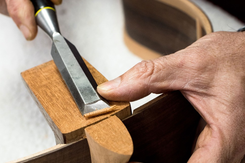 
				Millimeterarbeit: Mit dem Stechbeitel legt José Rodríguez Peña letzte Hand an den Halsfuss. Anschliessend wird der Gitarrenboden aufgesetzt

			