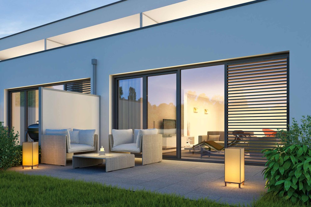 Terrasse avec mobilier de jardin et éclairage devant une maison moderne
