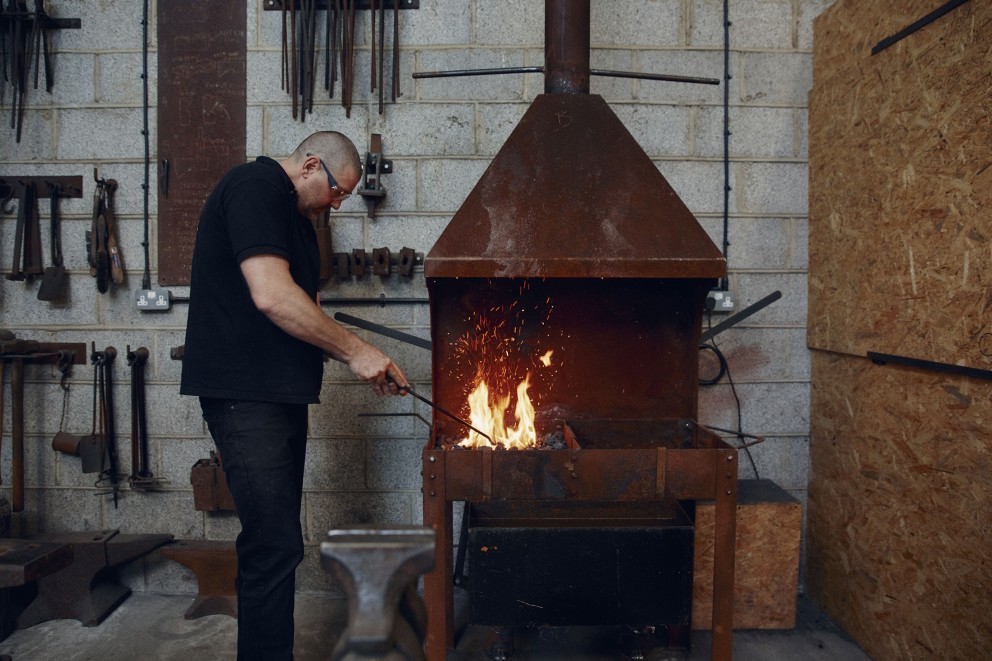 Heiss und karg: Alex schürt mit Haken das Feuer in der Esse. Heiss und karg: Alex schürt mit Haken das Feuer in der Esse.