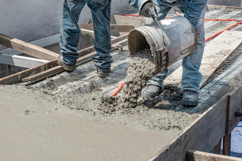 Bauarbeiter giessen Beton auf einer Baustelle