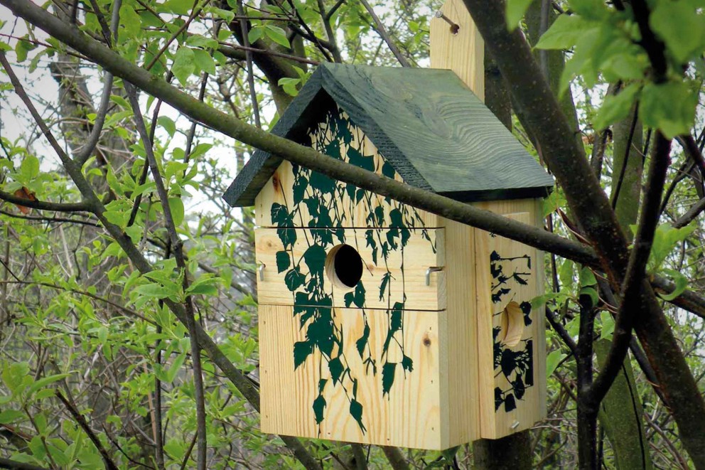 Nichoir en bois avec motif de vigne sur un arbre
